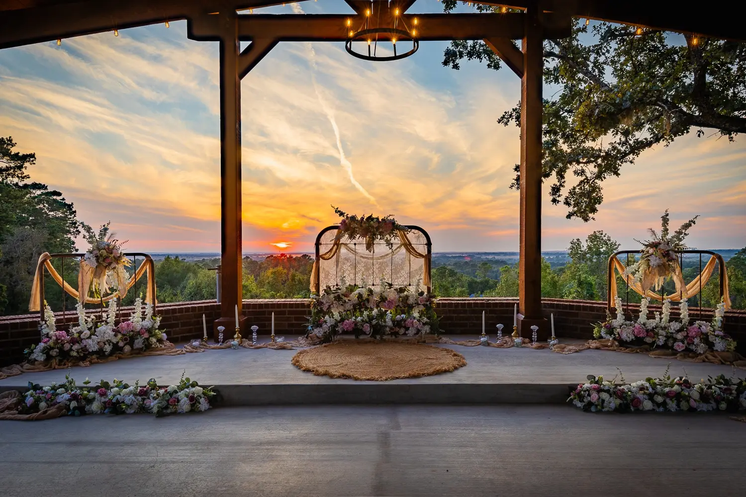 Floral ceremony setting beneath the pavilion with sunset views